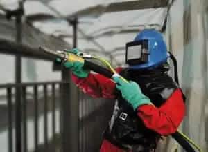An abrasive blast cleaner working