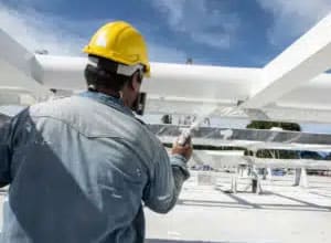 Worker applying thin film intumescent outside